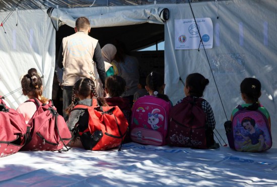 10月13日,在叙利亚西北部的塞勒马,孩子们等待进入用帐篷搭建的临时教室内上课。新华社发