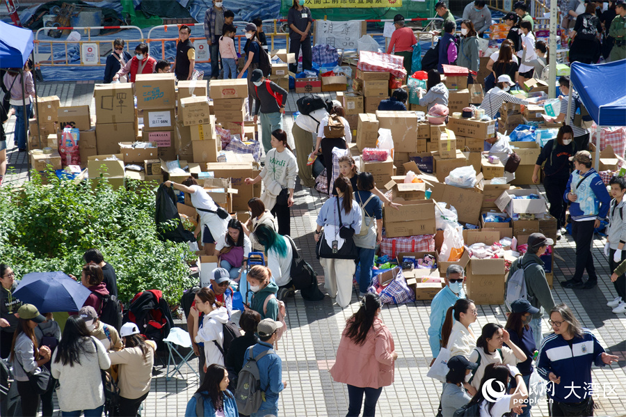 在宏福苑附近的广福邨公众活动平台上,义工和热心市民正在搬运分发各类物资。人民网 吴宇扬扬摄
