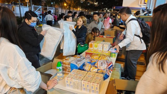 11月26日,受火灾影响的居民在跨部门援助站领取救援物资。新华社记者 陈铎 摄