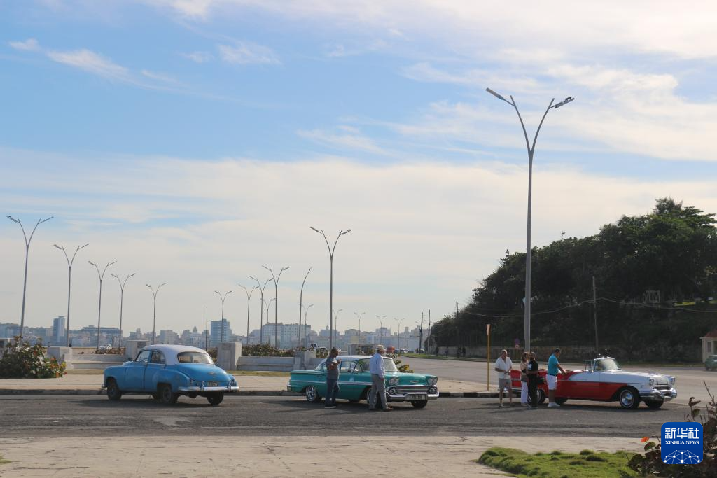 这是12月12日在古巴首都哈瓦那拍摄的色彩鲜艳的老爷车。新华社记者 何冰 摄